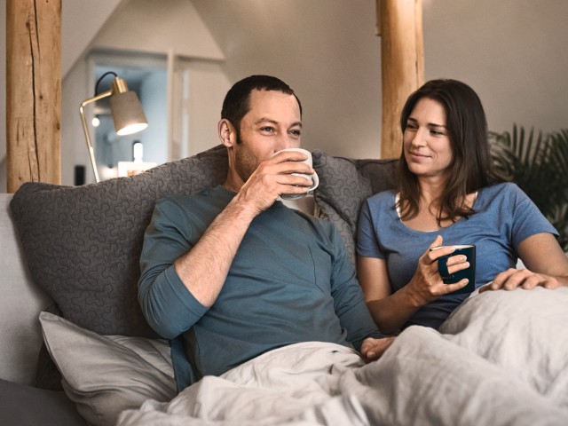 Par sidder på sofaen og drikker te
